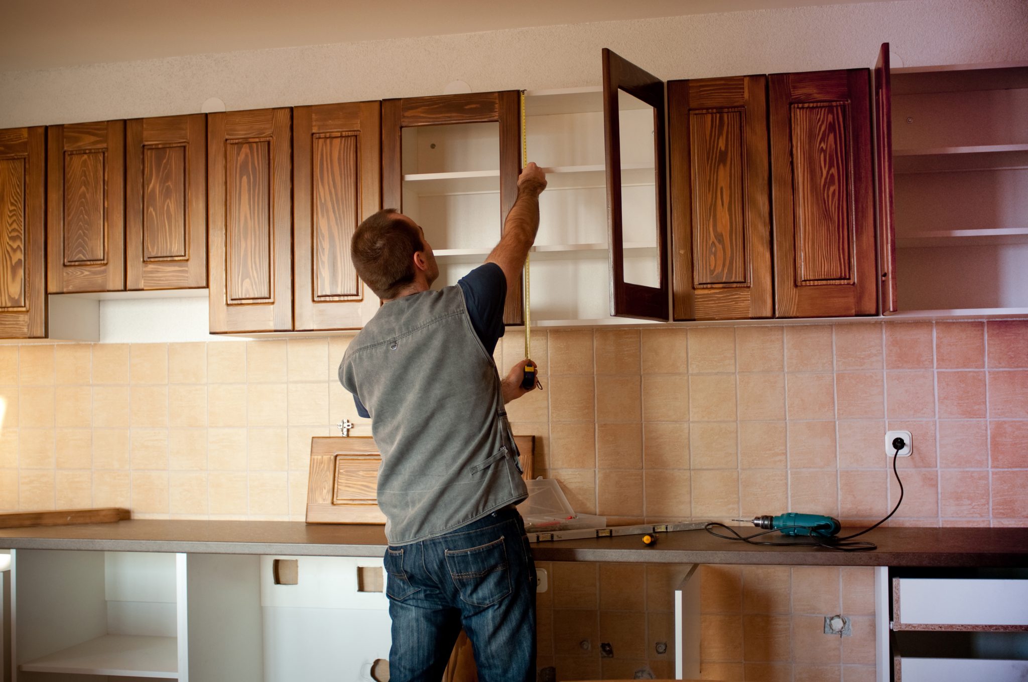 Carpenter working on new wooden kitchen cabinets